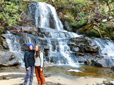 Graduate students Mary Grace Larson (left) and Maia Caddle hiked to a waterfall in the Great Smoky Mountains National Park as part of their research about programs offered by the National Park Service.